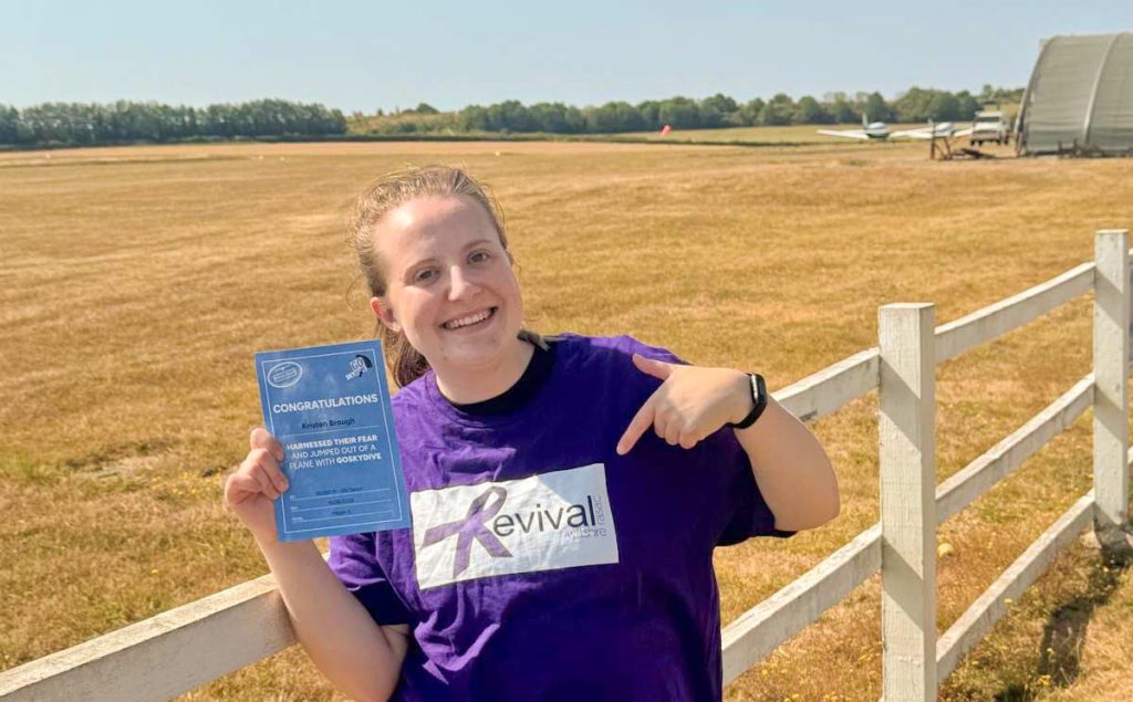 Kristen with her Skydive certificate and Revival T-Shirt